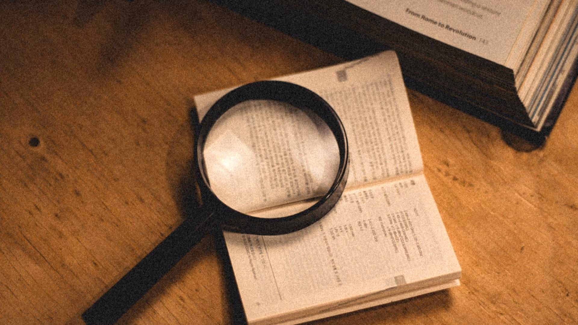 Loupe posee sur livre ouvert — expertise specialites pro AGI